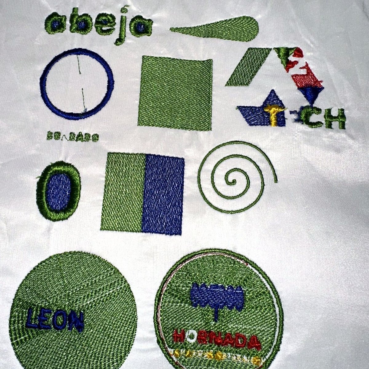 Doce logos bordados sobre tela, resultado real de archivos .PES generados por la herramienta